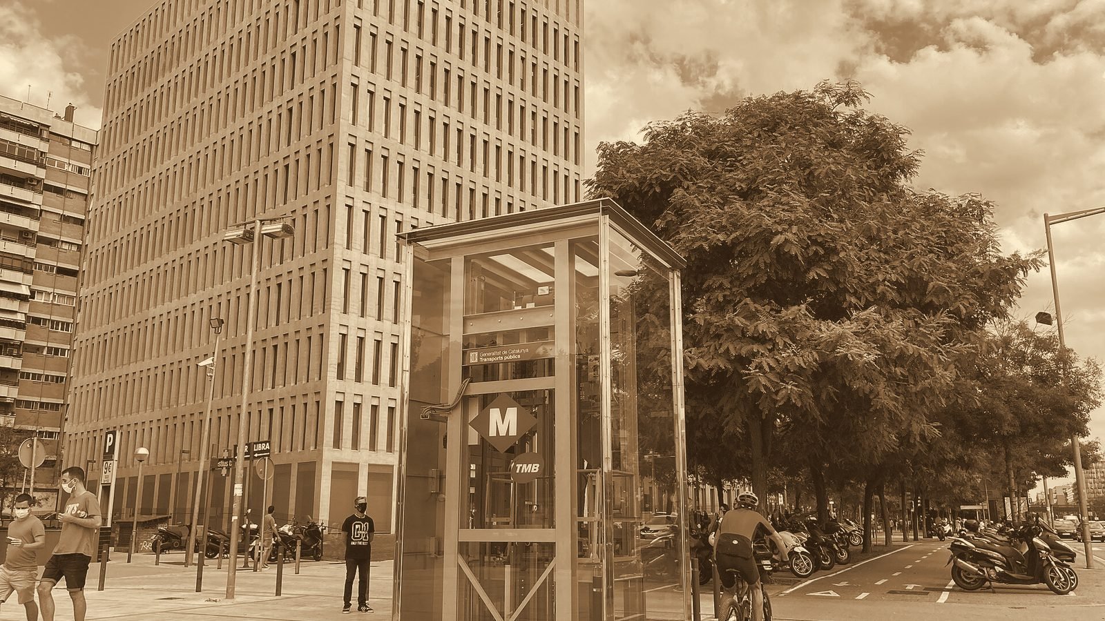Edificio de la Ciutat de la Justícia de Barcelona con un acceso de metro en primer plano, en tono sepia