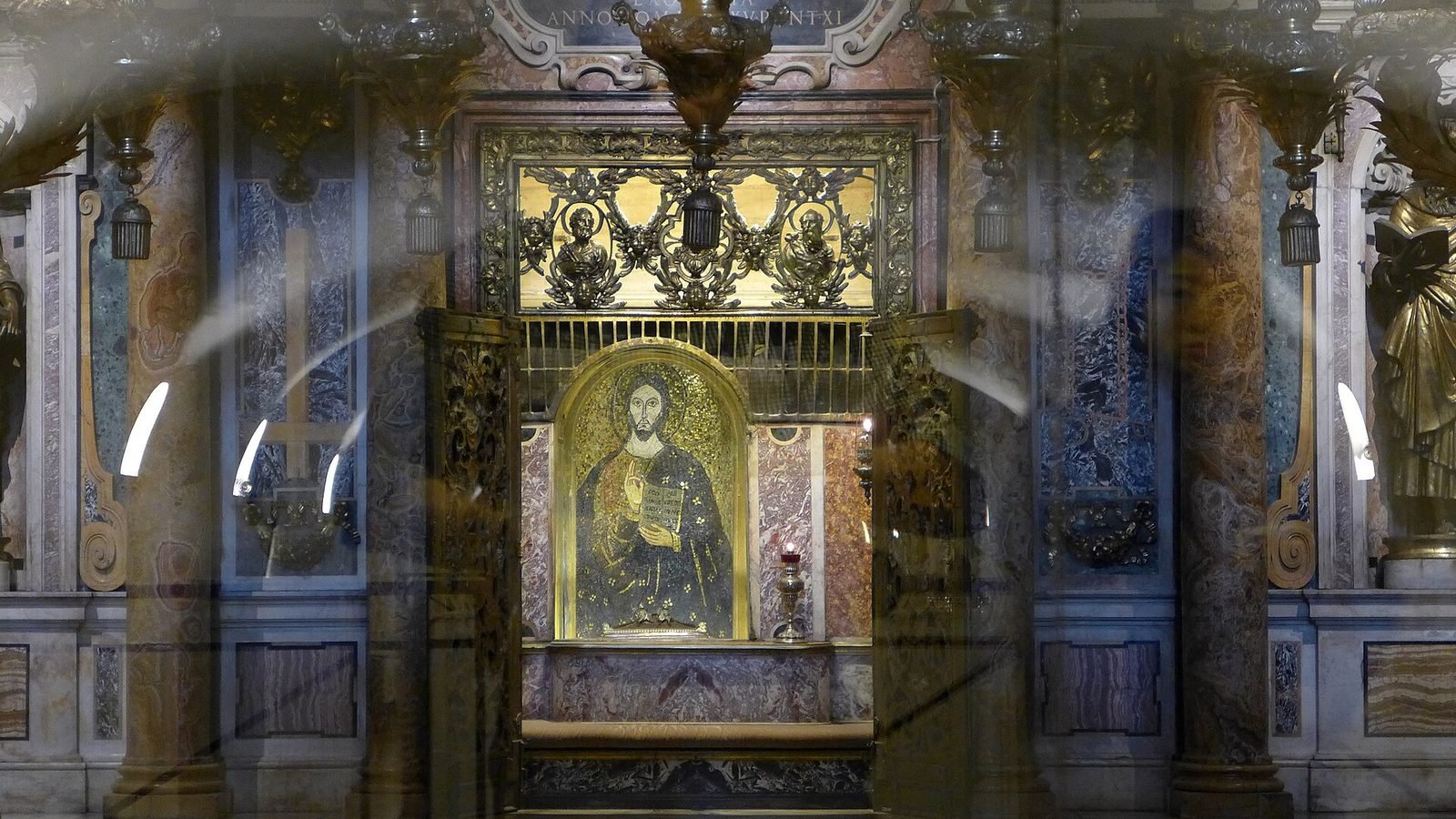 Nicho dorado con un mosaico de Cristo tras un cristal y una reja, sobre la tumba de San Pedro bajo el altar papal en las Grutas Vaticanas